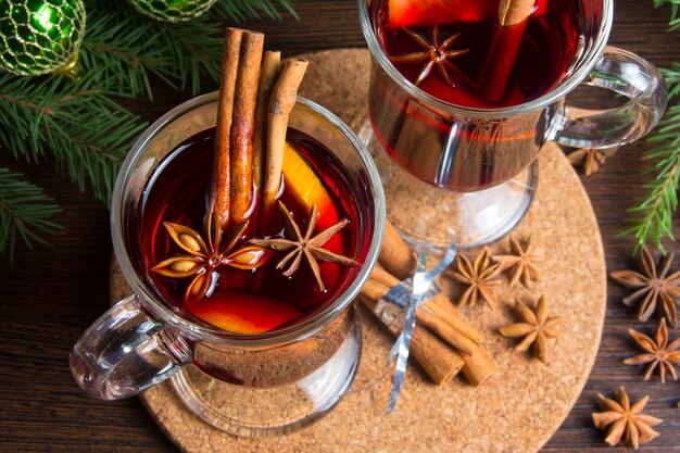 Christmas mulled wine with cinnamon and orange. on the table are spruce twigs and toys
