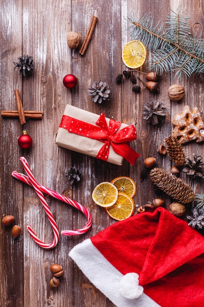 Christmas and New Year decor. Present box with red ribbon lies on a table with cookies