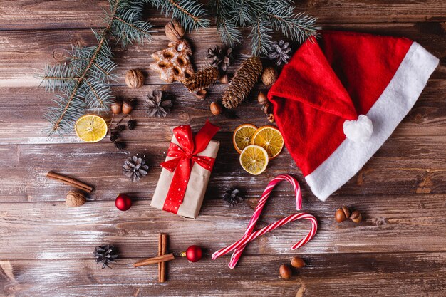 Christmas and New Year decor. Present box with red ribbon lies on a table with cookies