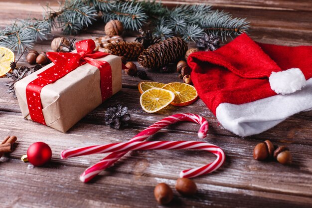 Christmas and New Year decor. Present box with red ribbon lies on a table with cookies