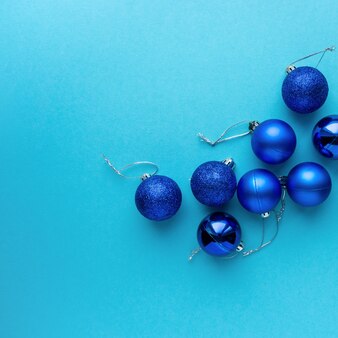 Рождественская или новогодняя композиция с синими шарами на цветном фоне, вид сверху