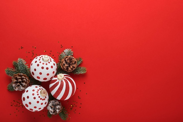 빨간색 배경에 장식된 리본과 전나무 나뭇가지가 있는 흰색 및 빨간색 공, 선물 상자, 샴페인이 있는 크리스마스 또는 새해 컨셉입니다. 새해 복 많이 받으세요 2022. 조롱.