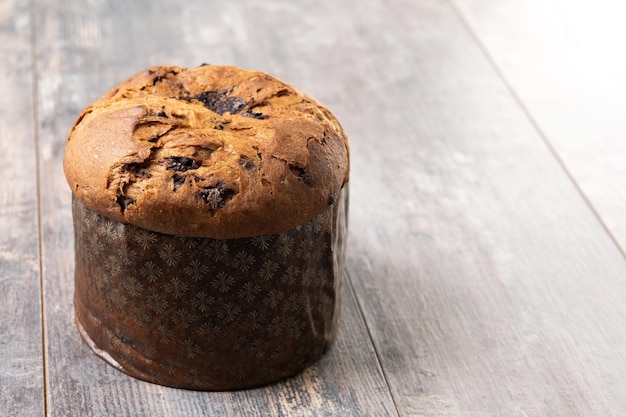 Foto gratuita torta di panettone di natale con cioccolatini su un tavolo di legno