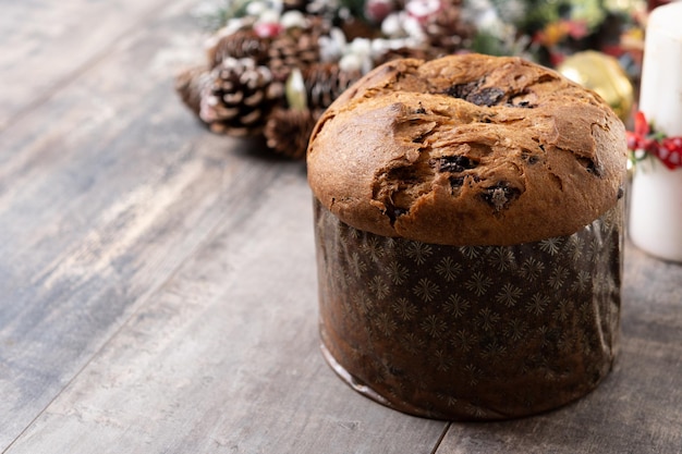 Foto gratuita torta di panettone di natale con cioccolatini su un tavolo di legno