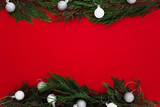 Christmas pine leaves on a red background with a blank note