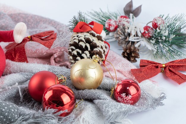 Christmas pinecone with baubles on white surface