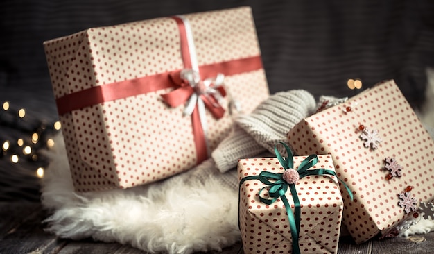 Christmas presents over lights on dark wall on cozy rug. Holiday decorations