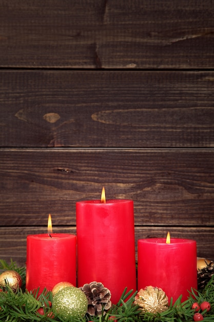 Free photo christmas red candles with wooden background