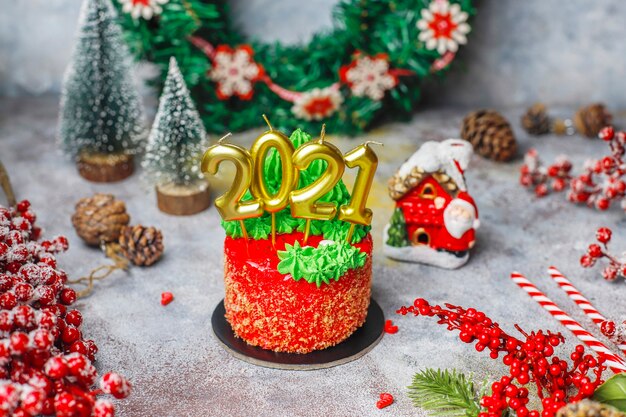 Christmas small cake decorated with sweet figures of christmas tree,santa claus and candles.