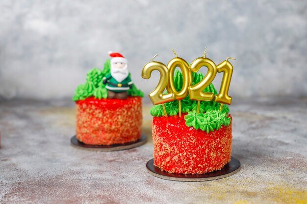 Рождественский торт украшен сладкими фигурками елки, Санта Клауса и свечей.