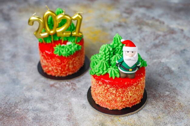 Christmas small cake decorated with sweet figures of christmas tree,santa claus and candles.