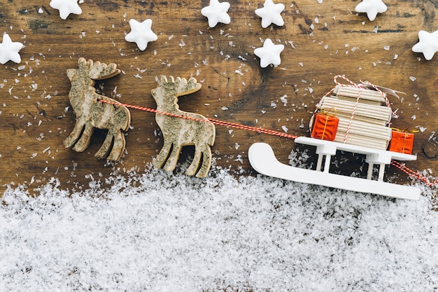 Decorazione neve natalizia con regali sulla slitta