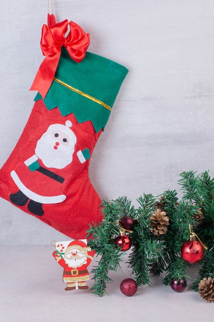 Бесплатное фото Рождественский носок, полный праздничных шаров на белой поверхности