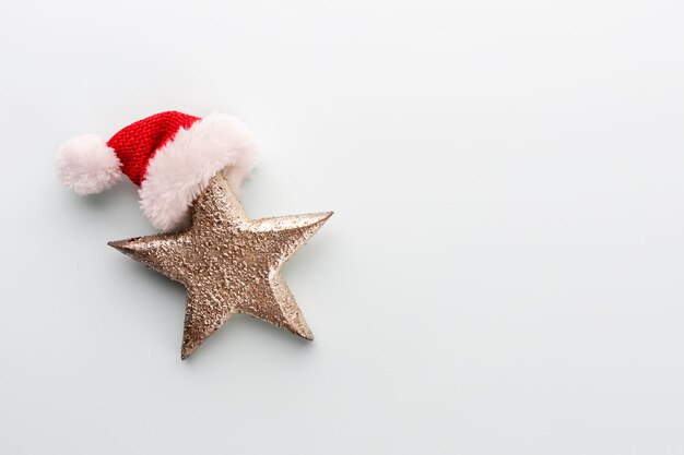 Рождественская звезда и шляпа санты, декор на пастельно-голубом фоне.