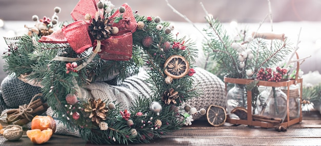 Christmas still life of a live Christmas tree, decorations and festive wreath on a background of knitted clothes