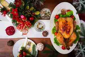 Free photo christmas table served with a turkey, decorated with bright tinsel and candles