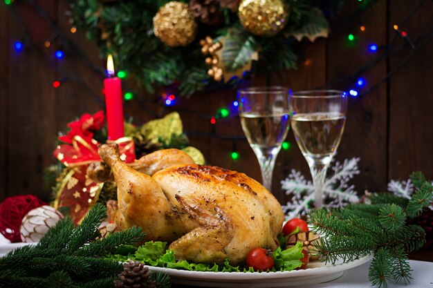 Christmas table served with a turkey, decorated with bright tinsel and candles.