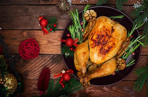 Christmas table served with a turkey, decorated with bright tinsel and candles