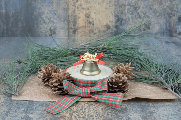 Free photo christmas toy with bow and two pinecones on marble background. high quality photo