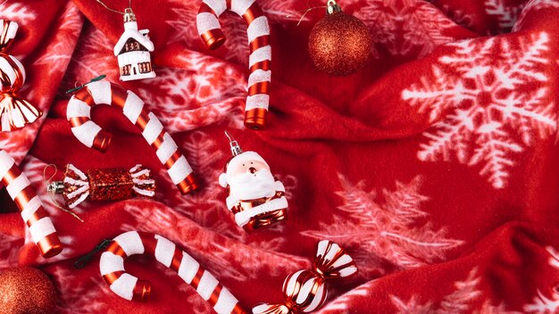毛布の上にキャンディーの杖を持つクリスマスのおもちゃ