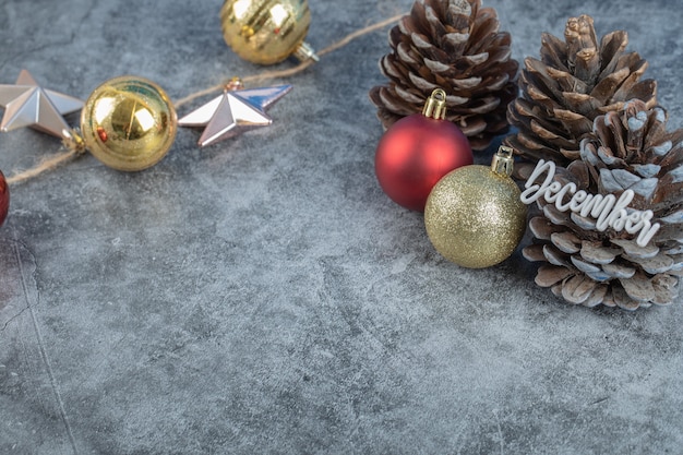 Christmas tree cone with december writing on it and glittering figures around