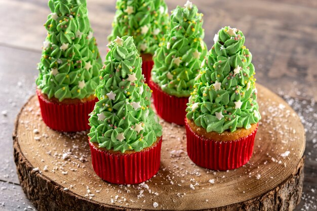 Christmas tree cupcakes on wooden table