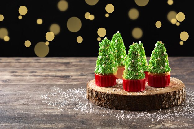 Christmas tree cupcakes on wooden table