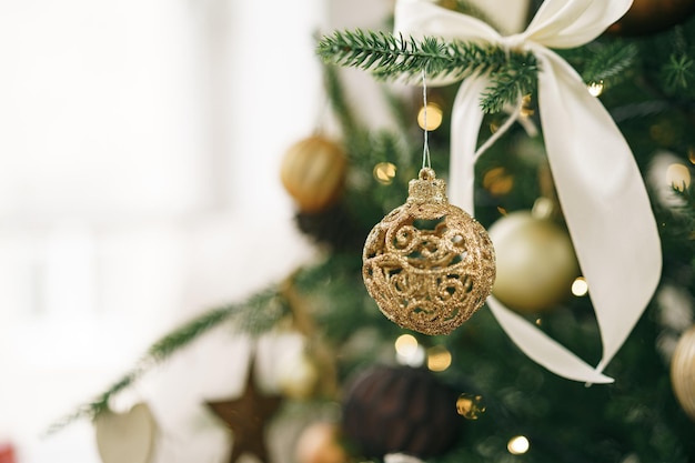 흰색과 황금색 공으로 장식된 크리스마스 트리를 닫습니다.