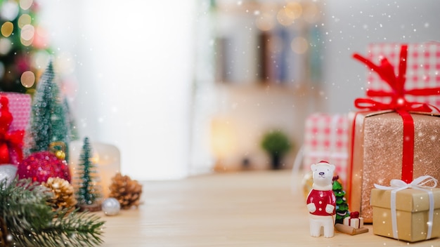 Christmas tree and new year holidays gift box with decorative ornament on wood table with snowfall.gifts and congratulations banner background concept.