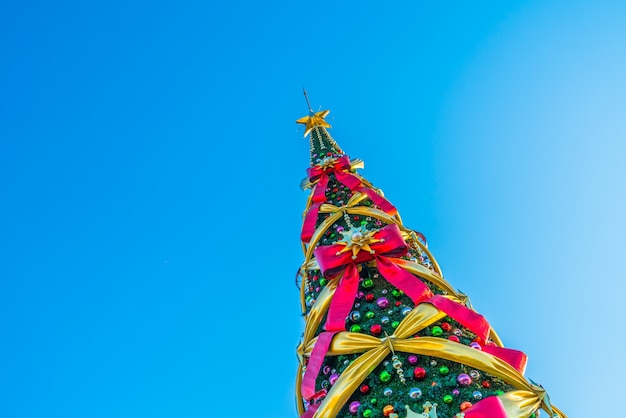 対角線上の青い背景に大きな弓とクリスマスツリー