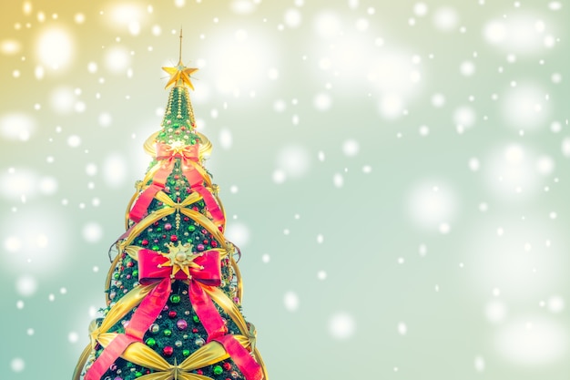 Рождественская елка с большими бантами на синем фоне с огнями