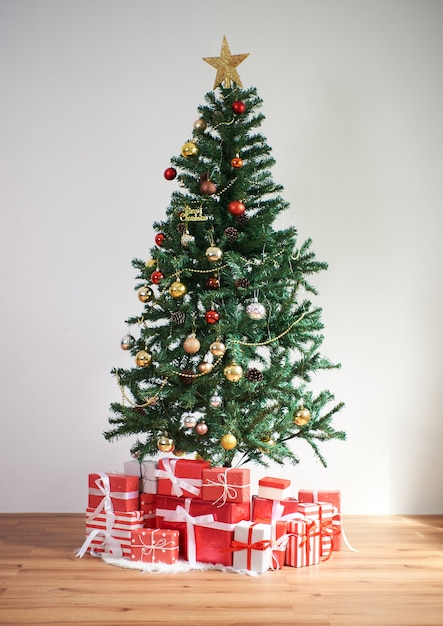 明けましておめでとうとクリスマスのコンセプトのリビングルームの装飾に赤い贈り物とクリスマスツリー