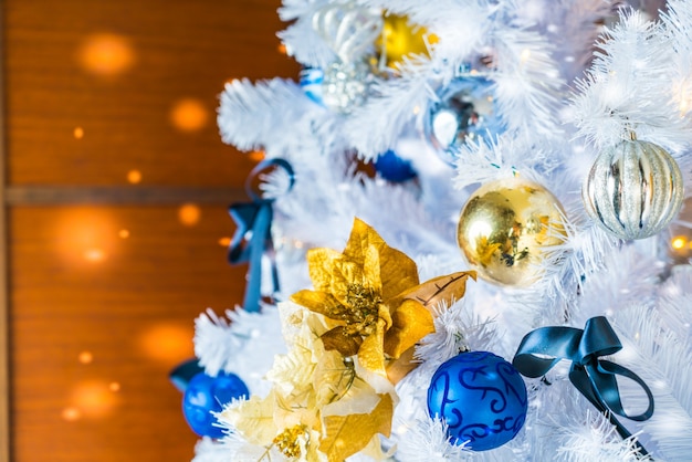 Christmas tree with white branches, golden stars and blue balls