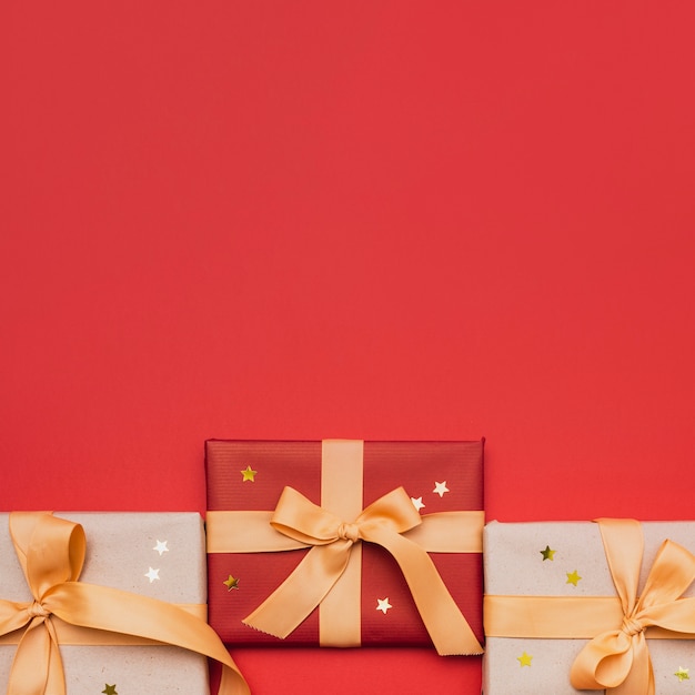 Free photo christmas wrapped gift with stars on red background