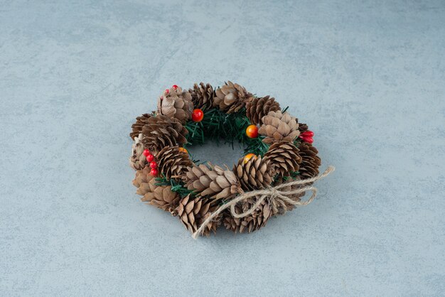 Free photo a christmas wreath from pinecone on marble background. high quality photo