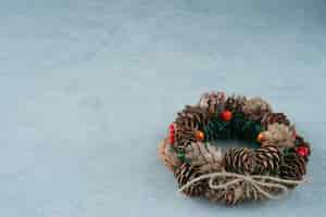 Free photo a christmas wreath from pinecone on marble background. high quality photo