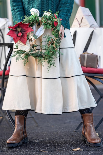 スタイリッシュな女性の街歩きの手にクリスマスリース