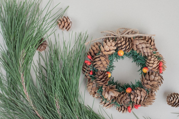 Christmas wreath and pinecones on beige surface