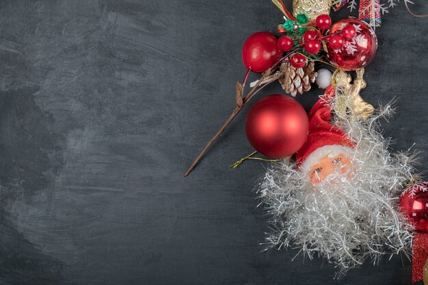 Christmas wreath with baubles and Santa on dark surface