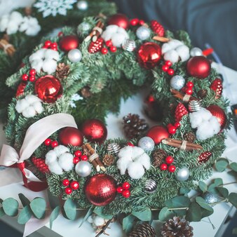 크리스마스 장식, 상록 크리스마스 트리 나뭇가지, 빨간 유리 공 및 홀리 베리가 있는 크리스마스 화환