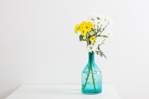白い​背景​の​上​の​ガラス​の​花瓶​に​菊​の​花