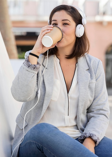 Бесплатное фото Пухлая девушка, наслаждаясь кофе на открытом воздухе
