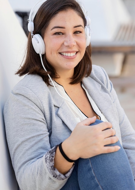 Chubby girl listening to music outdoors