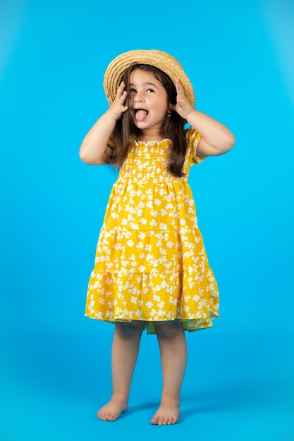 The chubby little happy girl is naughty in the studio and poses in different poses