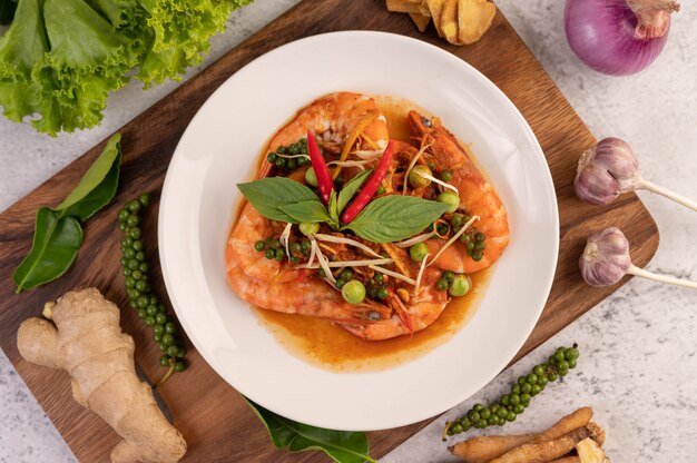 Chuchi shrimp on a plate with fresh pepper seeds