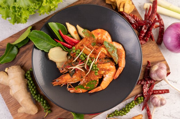 Chuchi shrimp on a plate with fresh pepper seeds