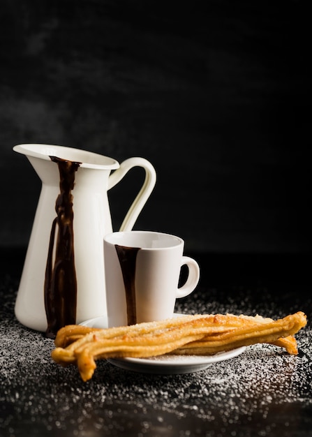 Churros on plate and containers filled with chocolate