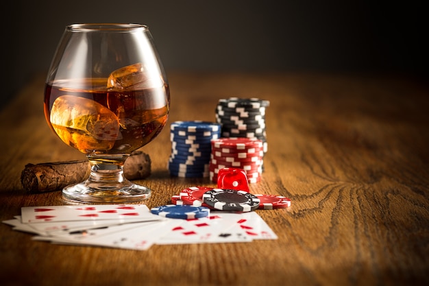 Cigar, chips for gamblings, drink and playing cards