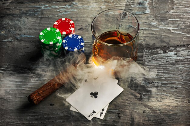 Cigar, chips for gamblings, drink and playing cards