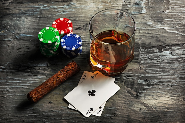 Cigar, chips for gamblings, drink and playing cards